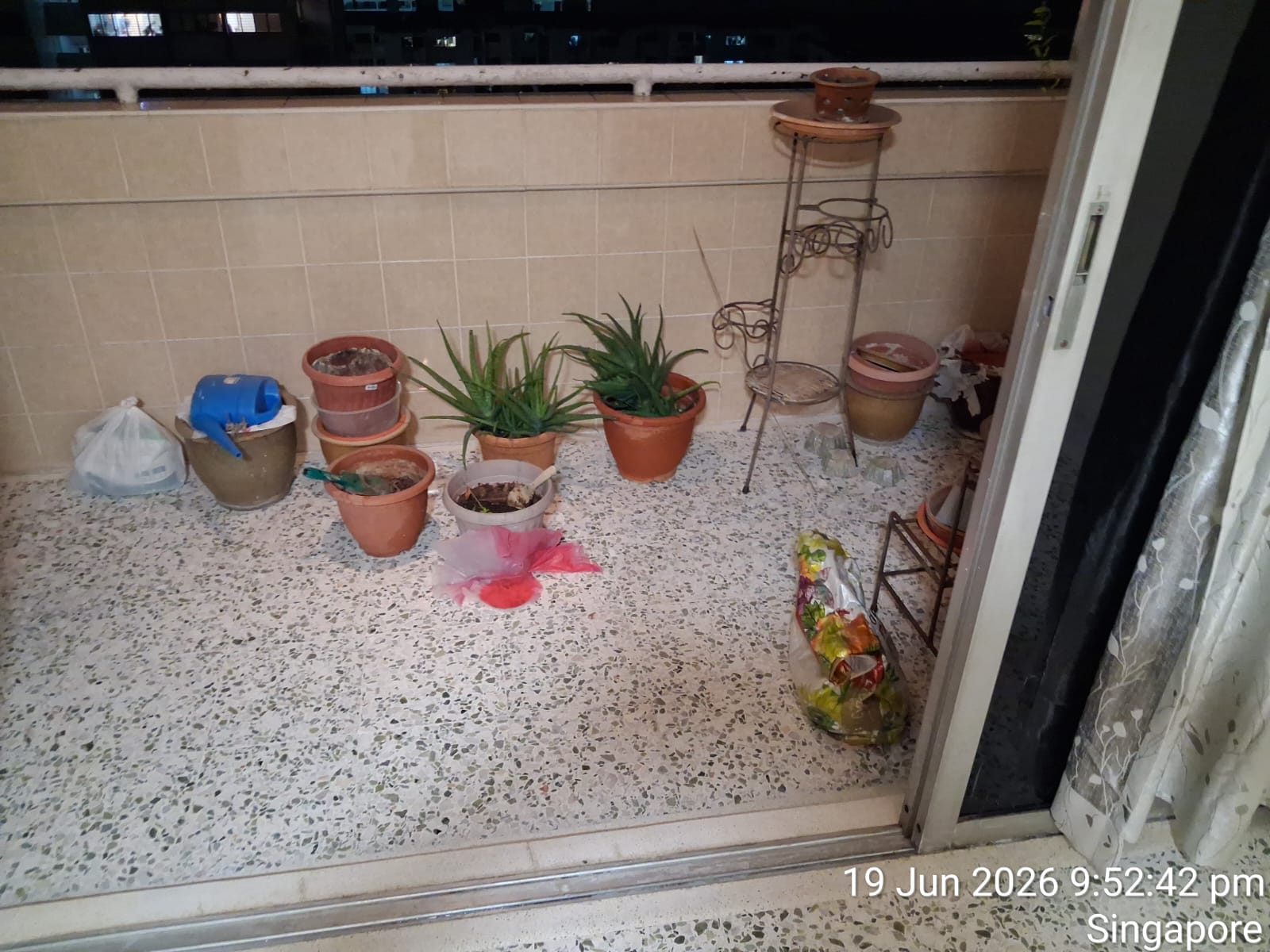 Terrazzo balcony floor with potted plants, before final clean-up — second photo